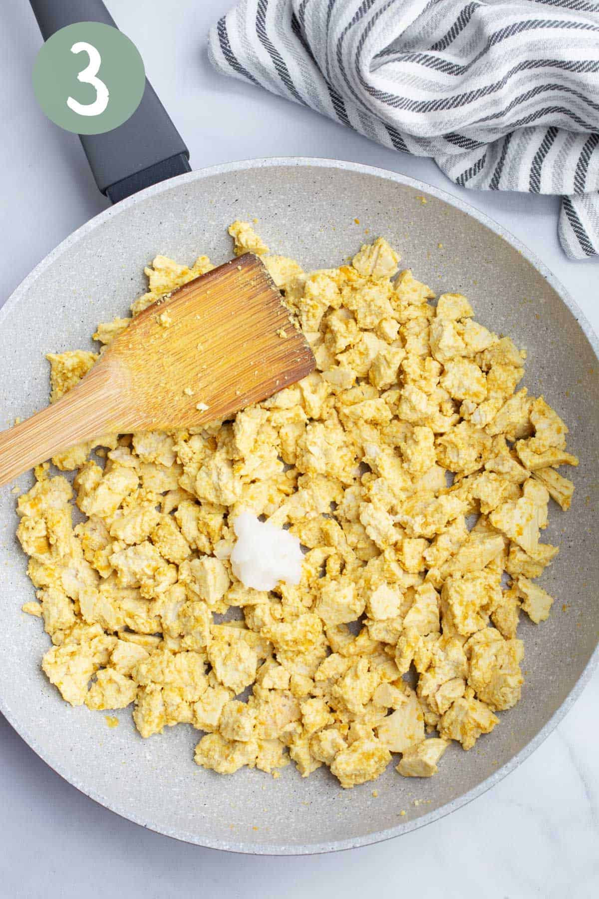 Raw tofu with seasonings and oil in a pan.