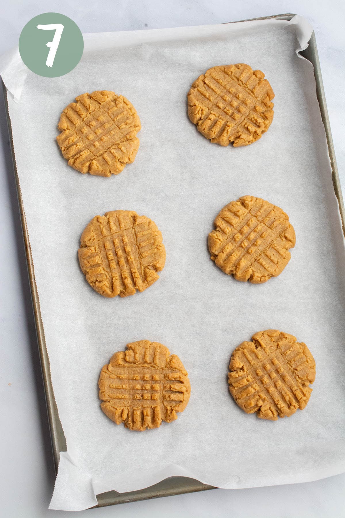 Baked vegan peanut butter cookies on a baking sheet lined with parchment paper.