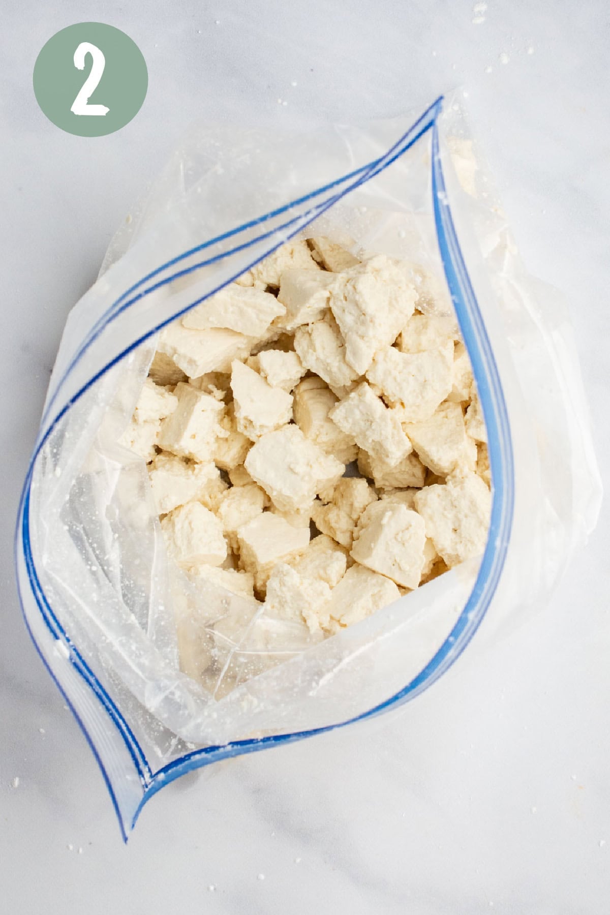 Tofu chunks in a bag with cornstarch.