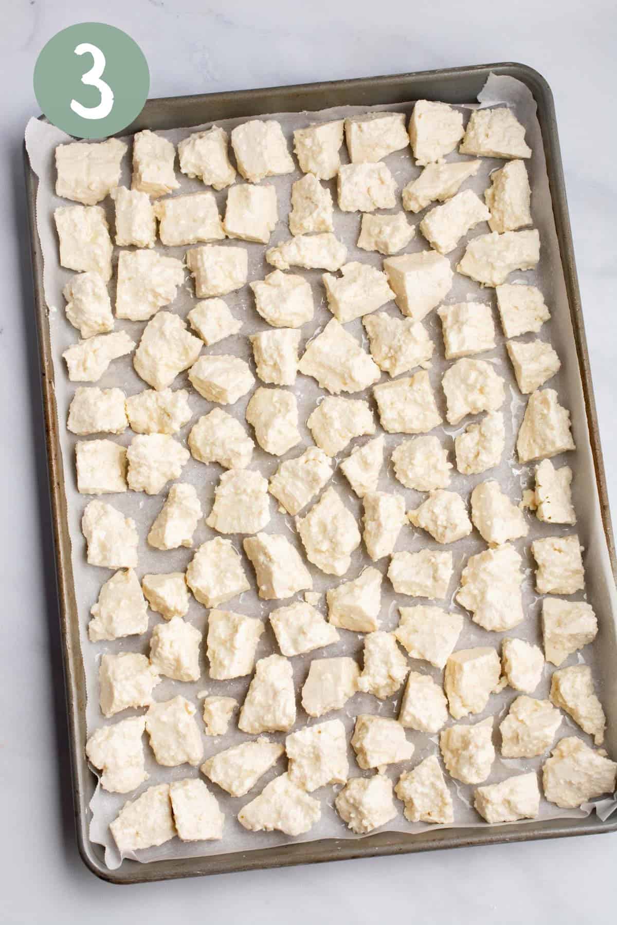 Tofu chunks on a baking sheet.