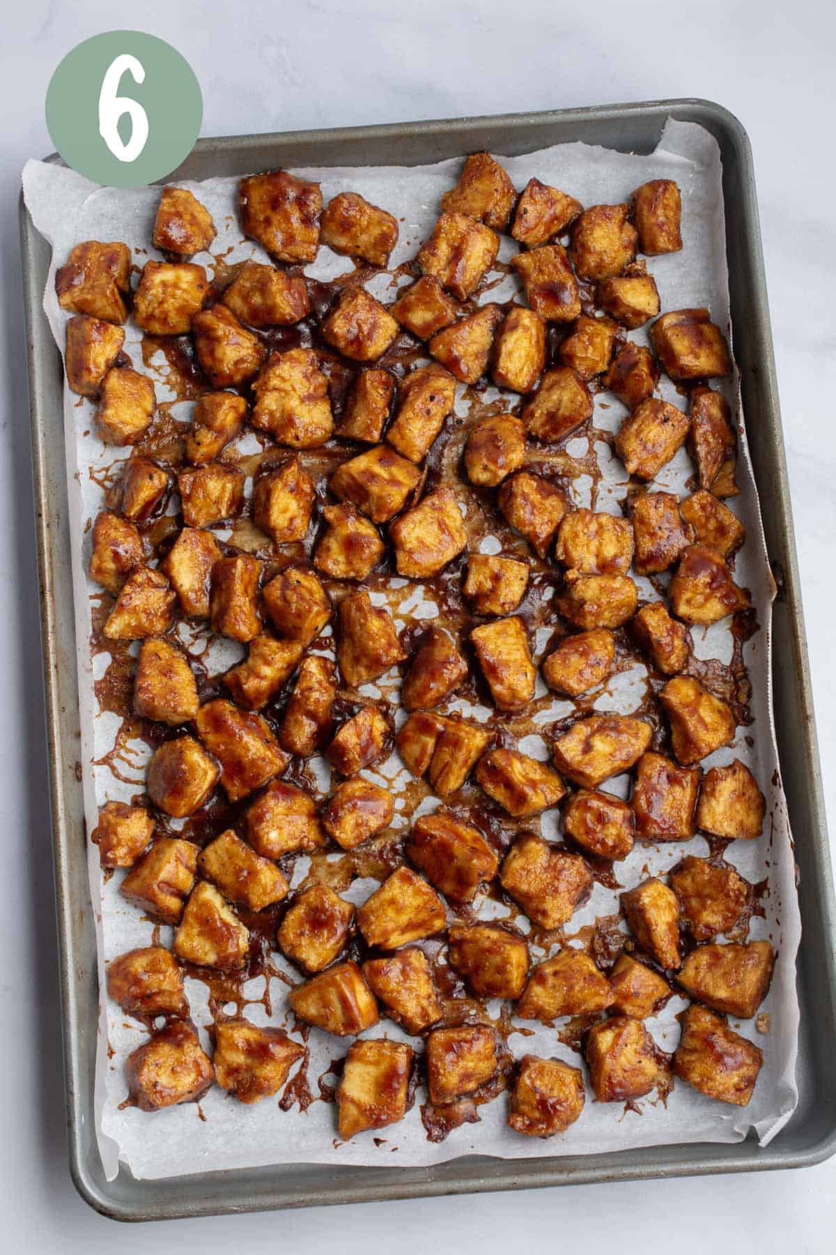 Baked BBQ tofu chunks on a baking sheet.