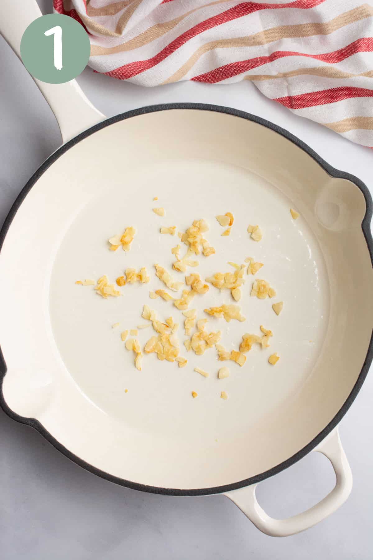 Sautéed garlic in a white pan.