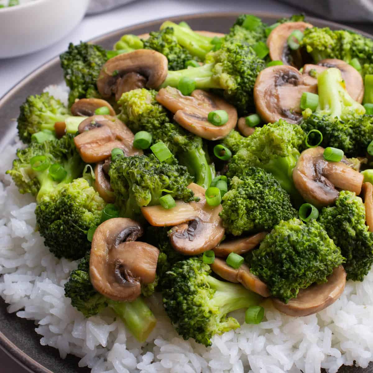 Stir-fried mushrooms and broccoli on a bed of white rice.