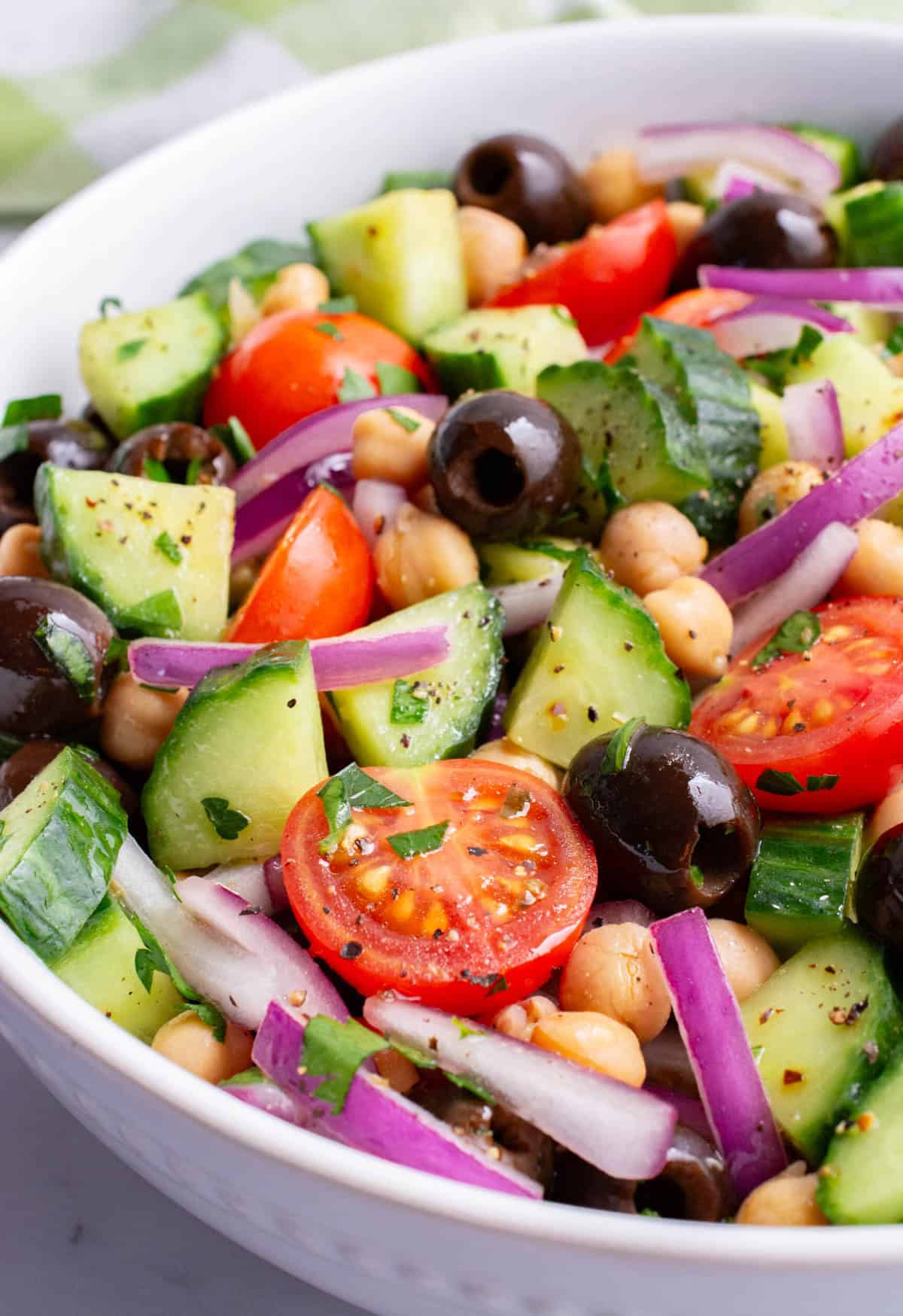 Mediterranean cucumber salad in a white serving bowl.