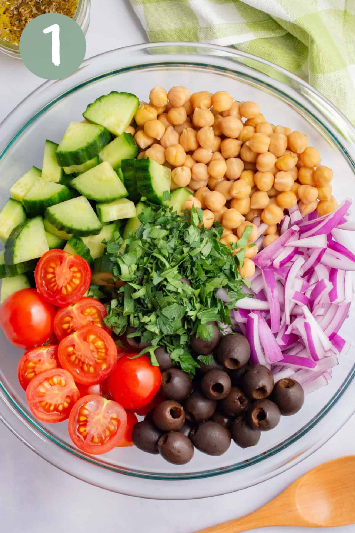 Chopped veggies in a glass bowl for vegan cucumber salad.